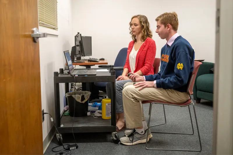 Zach Bergman and Katie Edler sit at a computer.