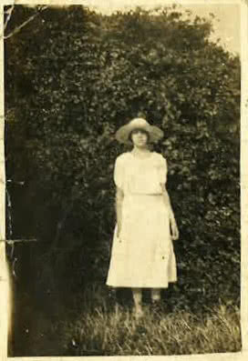 An old sepia tone photo from 1922 showing a girl wearing a dress and sun hat.