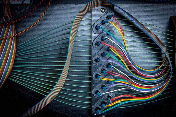 A series of cables are plugged into a panel.