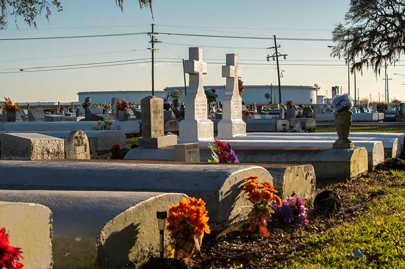 A cemetery in the foreground and a chemical plant in the background.