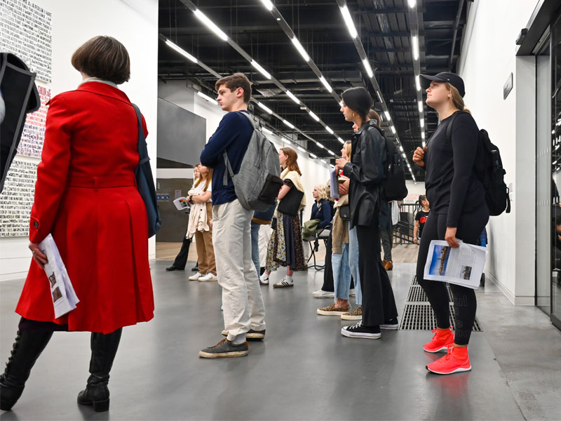 A group of students looks at artwork at the Tate Modern. The artwork is a paragraph of text.