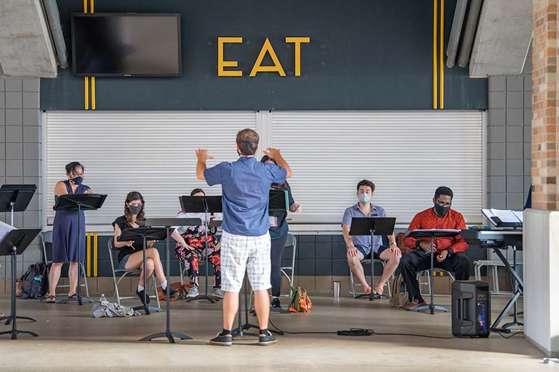 Students sing in front of an EAT sign.