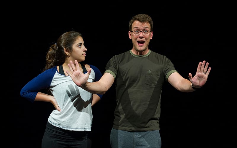 Pre College Rehearsal with Scott Jackson holding his hands out in front of hime and a young woman to his right