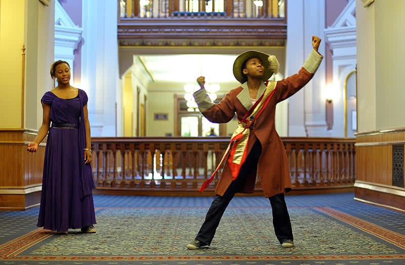 Two students from Robinson Community Learning Center, both young women, performing in the main building with the rotunda in the background