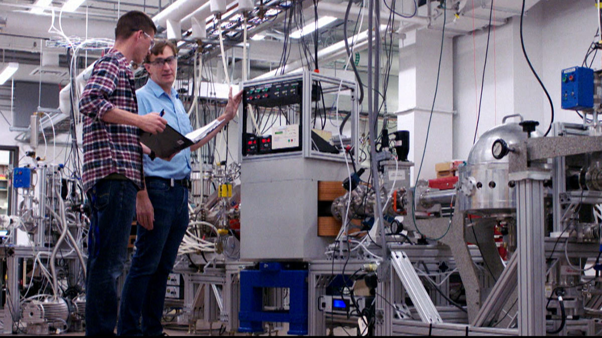 Grant Peaslee speaking with student in the lab