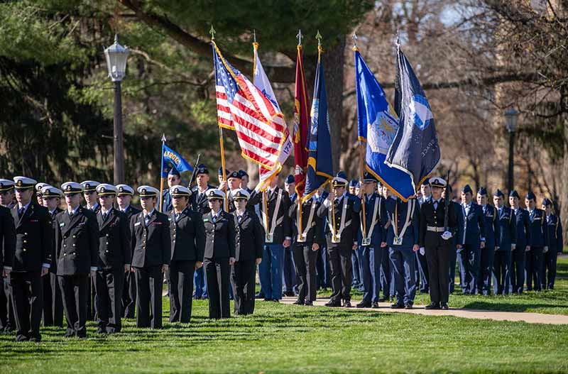 A large group of ROTC members stand in attention stance.