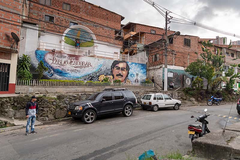 A large and colorful mural of Pablo Escobar and a written message “Welcome to the Pablo Escobar neighborhood”.