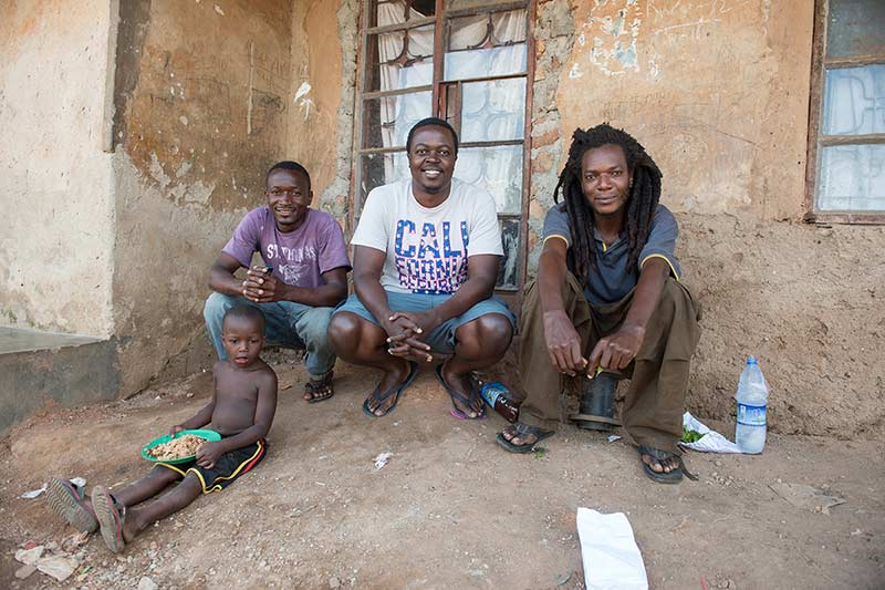 YALI fellow Alex Kawooya, (center) stops for a photo with childhood friends during his visit to Kalerowa slum where he was born and lived for 11 years in Uganda.