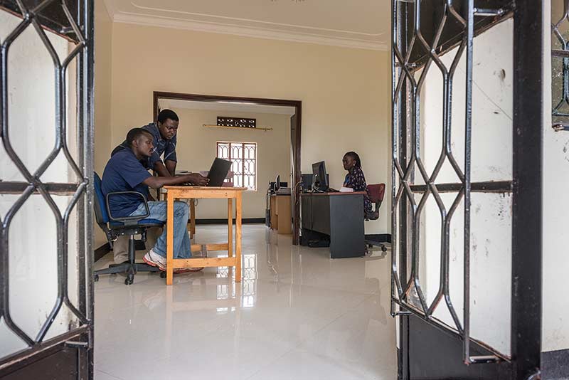 Alex Kawooya, managing director of Visions Unlimited and director of Rackmount, consults with an employee in his office in Kampala, Uganda.