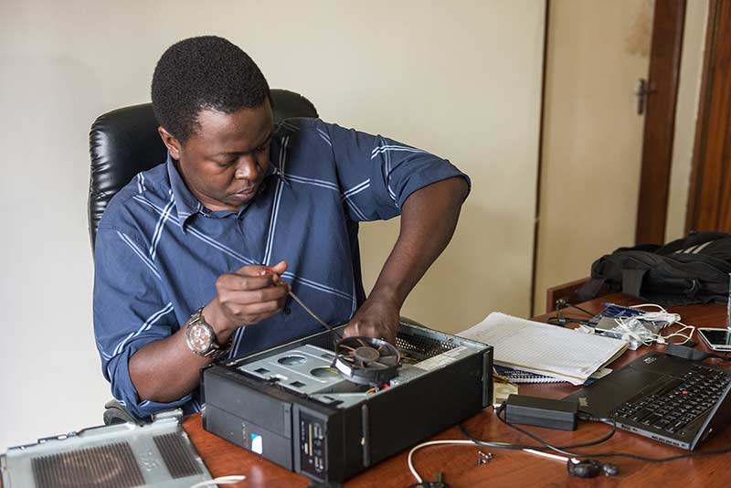 Alex Kawooya, managing director of Visions Unlimited and director of Rackmount, consults with an employee in his office in Kampala, Uganda.