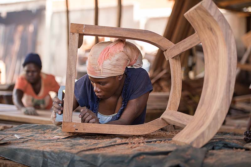 Woman from Awaka Furniture building a chair.