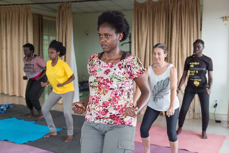 Apenyo leads African yoga stretches and movements.