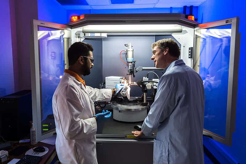 Two people in lab coats in a research lab.