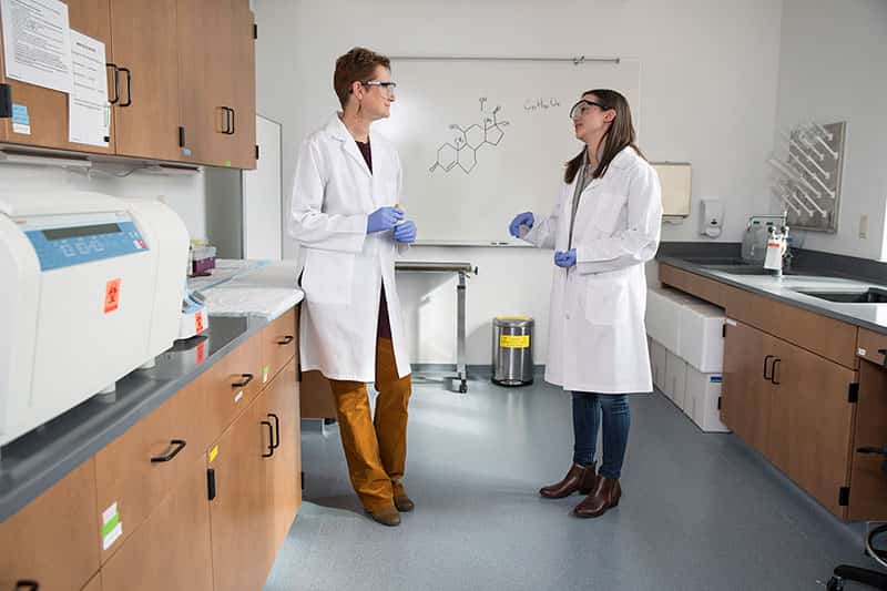 Two women in lab coats in a research lab.
