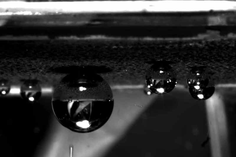 A black and white image showing nanostructured surfaces generating heat, and small bubbles begin to form from the surface in deionized water.