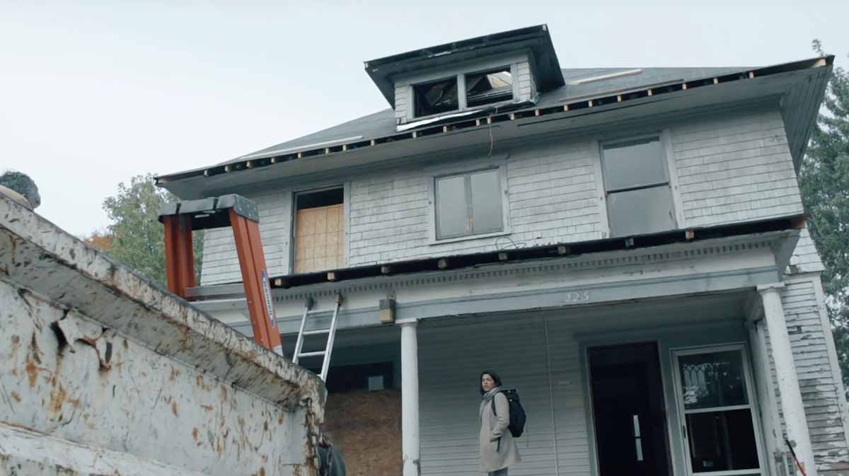 Melina Torres in front of an abandon building.