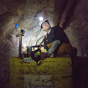 Jan 21, 2016; Infrastructure Technician and former gold miner Mike Oates, drives the train through a mine tunnel 4,850 below the surface in the Sanford Underground Research Facility in Lead South Dakota. The train used to move miners and ore, today it transports scientists and supplies. (Photo by Barbara Johnston/University of Notre Dame)