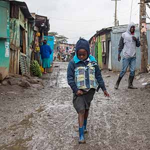 June 22, 2016; A girl walks on a muddy street in the Dandora slums of Nairobi, Kenya. (Photo by Barbara Johnston/University of Notre Dame)