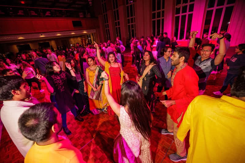 Diwali celebration showing colorful clothing, lights, and dancing.