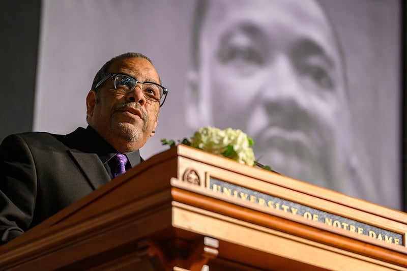 Rev. Hugh Page, Jr. speaking at a podium during ceremony on campus.