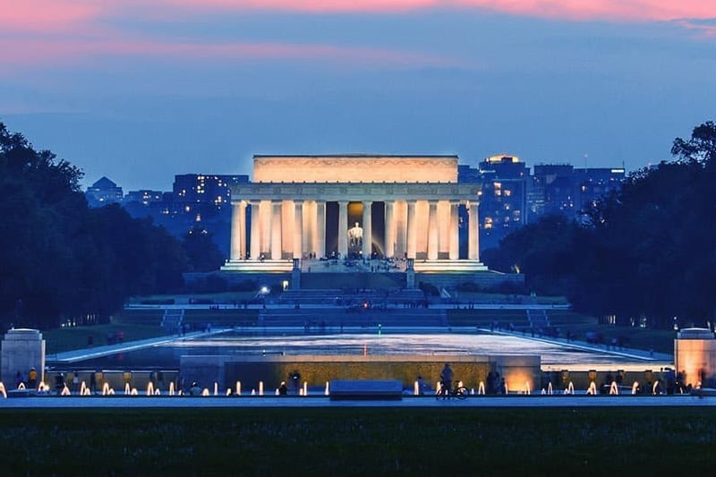 A view across the Capital Reflecting Pool at dusk to the Lincoln Memorial in Washington DC