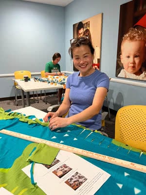 A woman cuts a fleece blanket.