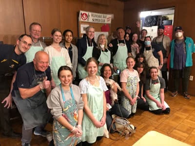 A group of volunteers pose for a photo in their aprons.