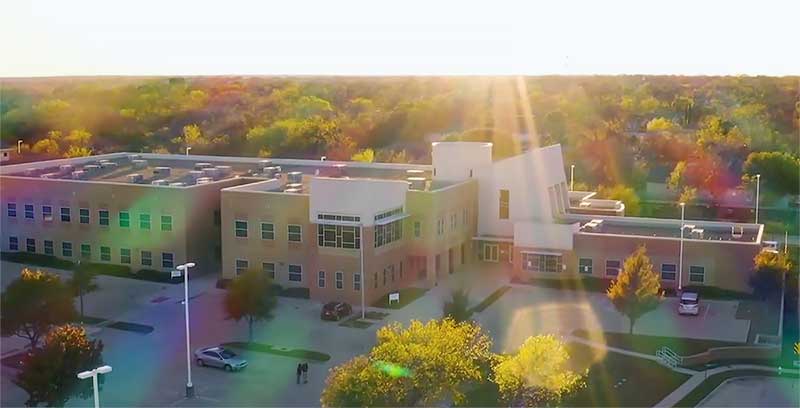 A sunray shines in front of the Catholic Charities of Fort Worth building.