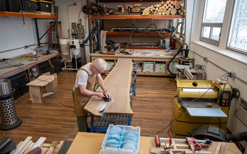 Fr. Groody working on sanding his river table.