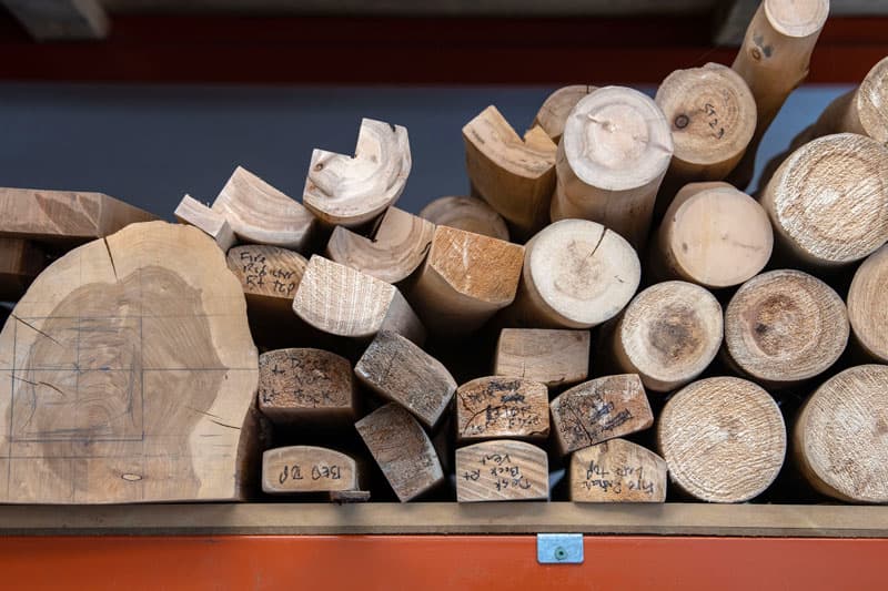 Logs of cut wood on a shelf.