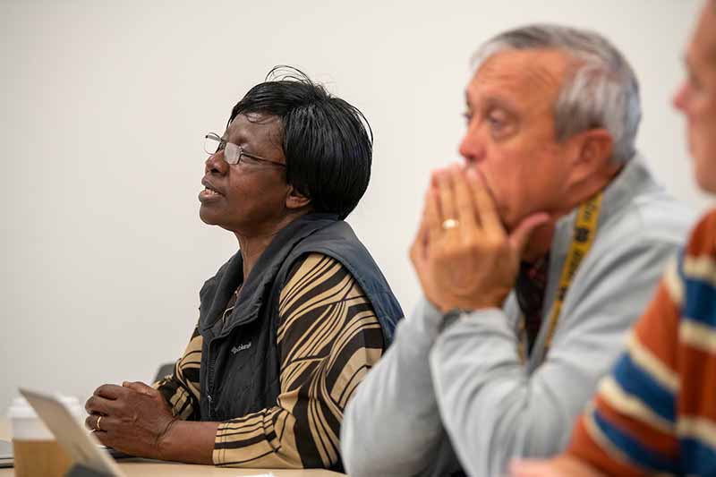 A woman and a man sit in a classroom.