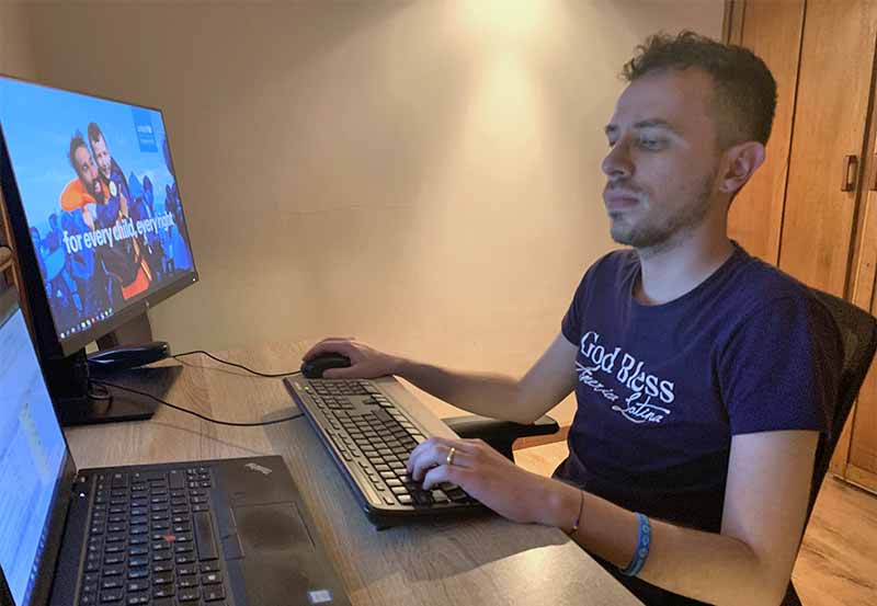 Juan sits at his computer desk.