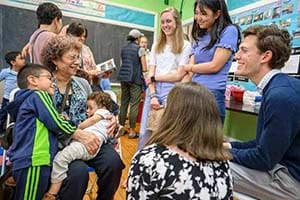 Students smile with family members.