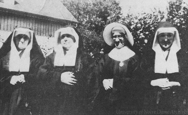 An archival photo of four sisters standing and looking at the camera.