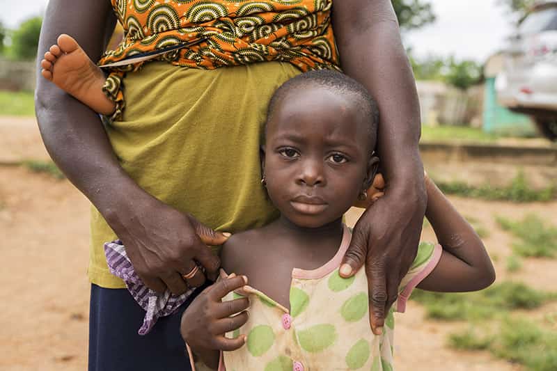 A woman wearing colorful patterns with her children.