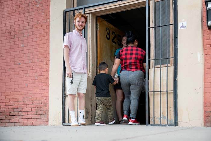 Brockman welcomes a mother and child into the building.