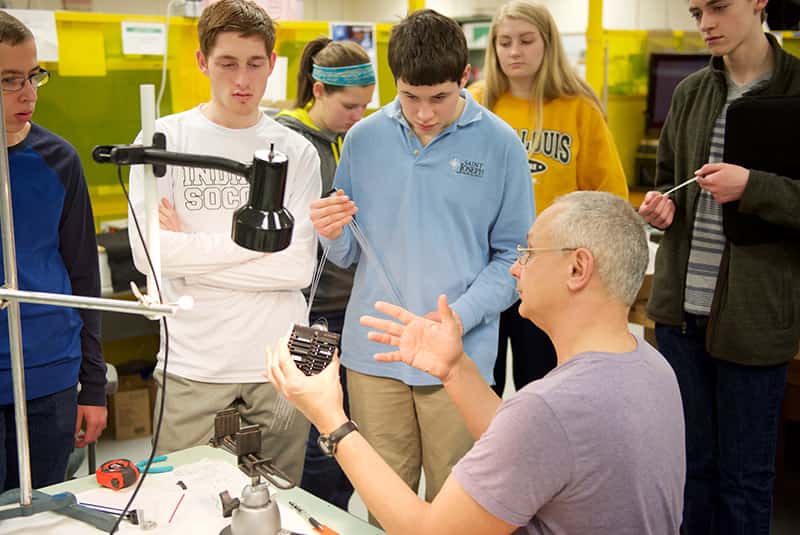 A male teacher is discussing with students.