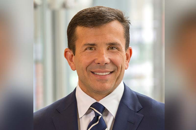 Headshot of John F. Crowley, a white man wearing a navy suit and tie.