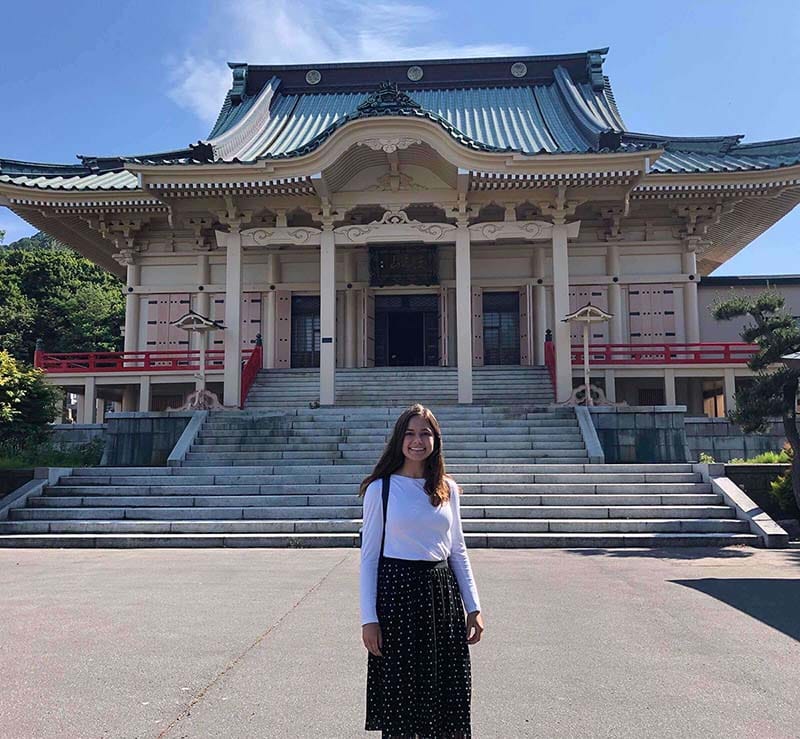 Francie stands in front of a Japanese temple.
