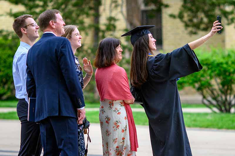 Graduates and families on Main Quad take a selfie.