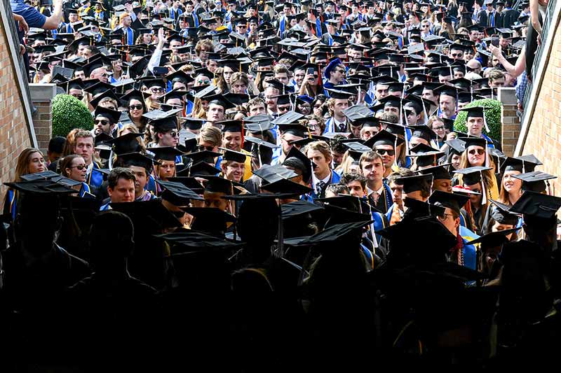 A large group of graduations gather in the entrance of the Notre Dame Stadium tunnel.