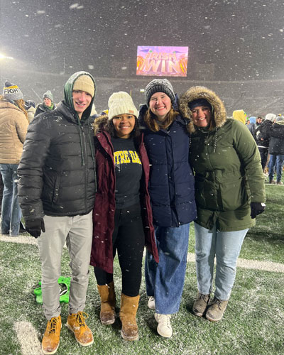 Audrey Miles stands on the football field at Notre Dame stadium with three friends. 