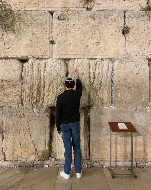 Blake Ziegler stands in front of the wailing wall.