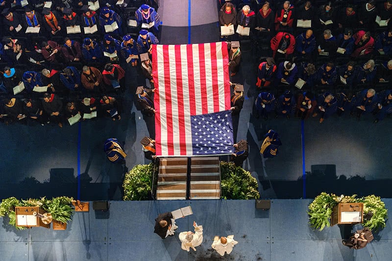 A United States flag is carried during commencement mass.