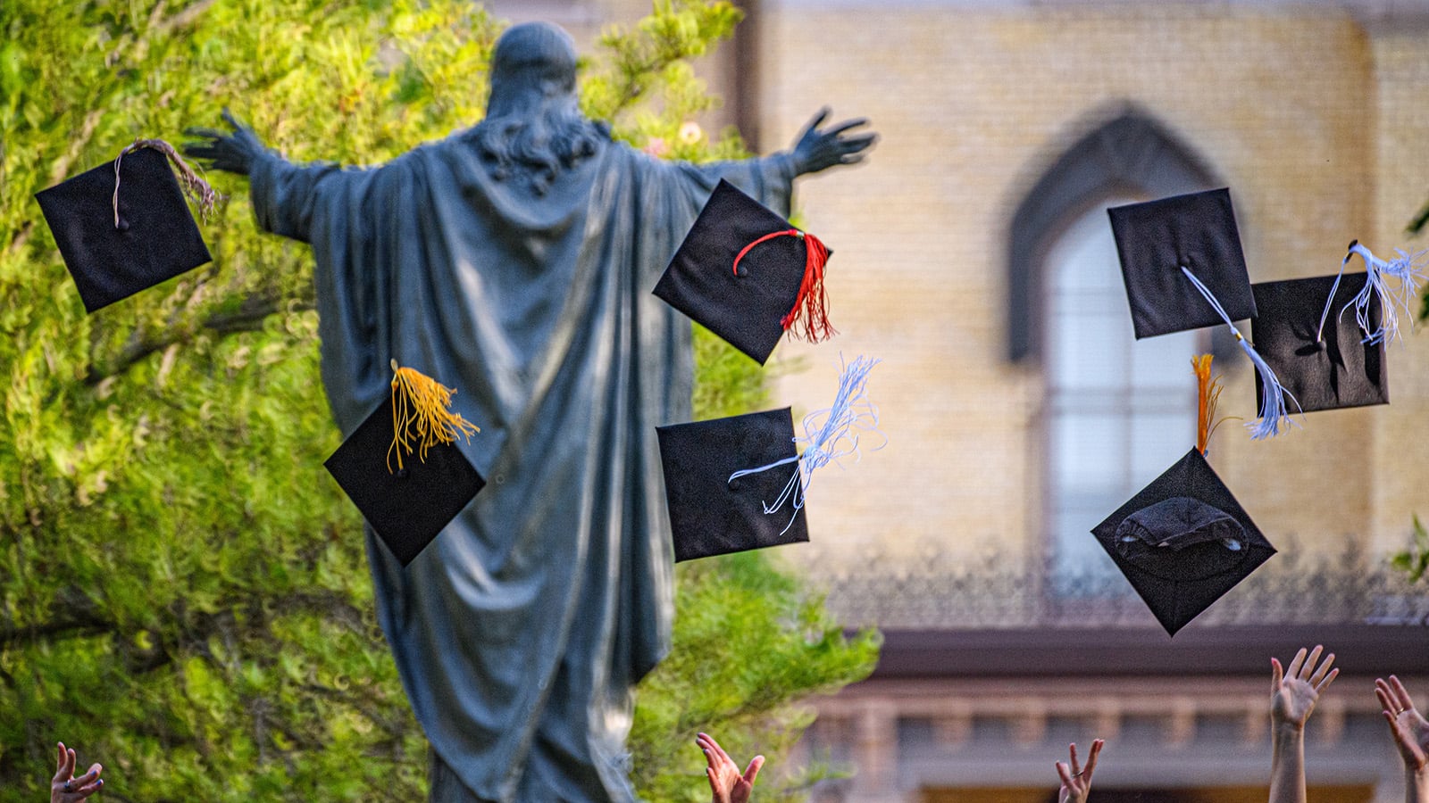 Graduates throwing caps into the air.