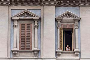 A woman looks out her window.