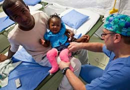 Doctor applies leg casts to a child in Haiti.