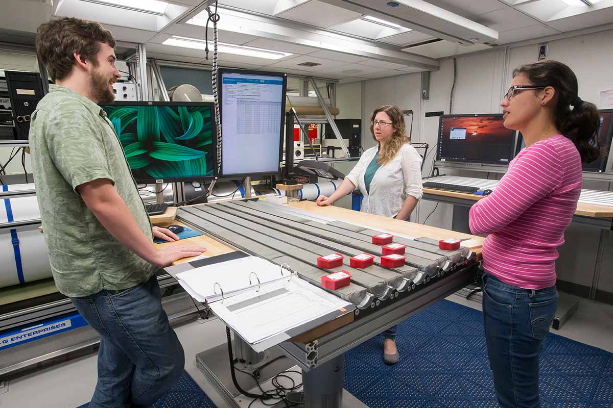 Melissa Berke, graduate student Cartagena Sierra and another scientist discuss preliminary tests on ancient mud samples