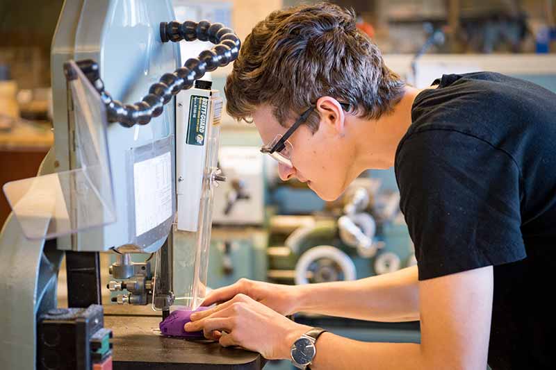 Cole Grabowski of e-NABLE ND makes adjustments to 3D-printed prosthetic hands.