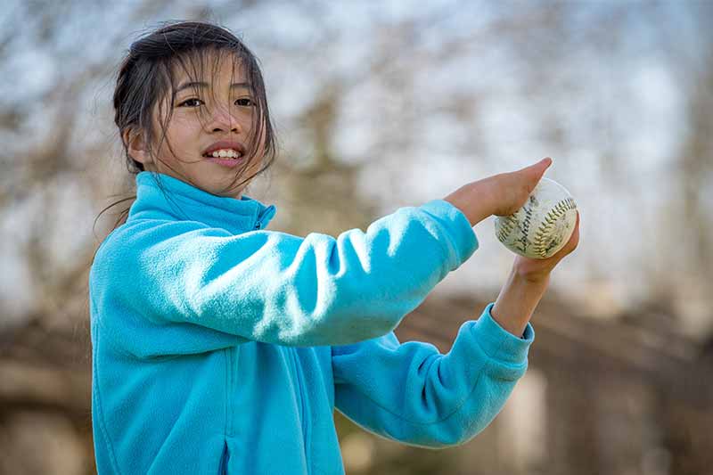 Tori Anderson gripping a softball with both of her fingers.